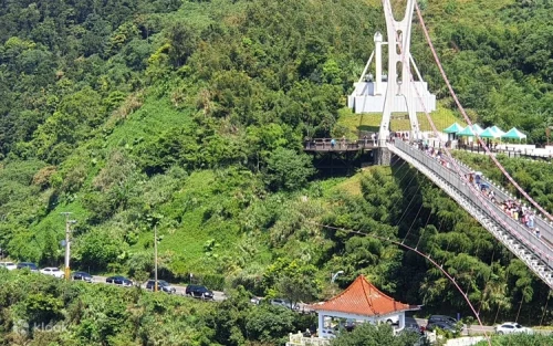 Visitors walking on the wooden planks of Taiwan's longest suspension bridge