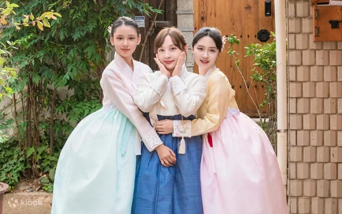 Couple wearing premium fusion Hanboks walking through historic Seoul courtyards