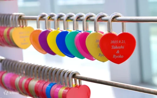 Couples attaching romantic heart-shaped padlocks at the rooftop fence