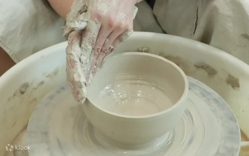 Participant molding a custom clay vase during a pottery class