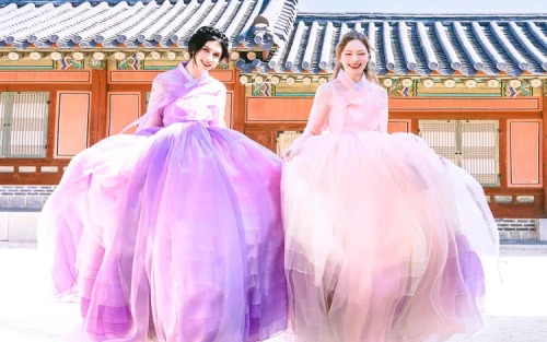 Family wearing matching premium Hanboks posing by historic South Korean architecture