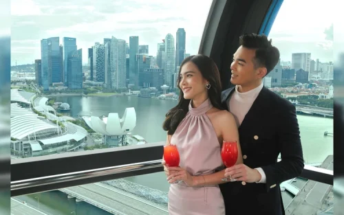 Iconic Singapore Sling cocktail with the city skyline in the background