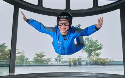 Visitor wearing complimentary flight suit and helmet during an indoor freefall