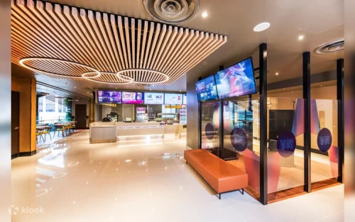 Friends sharing popcorn and drinks in the vibrant cinema foyer