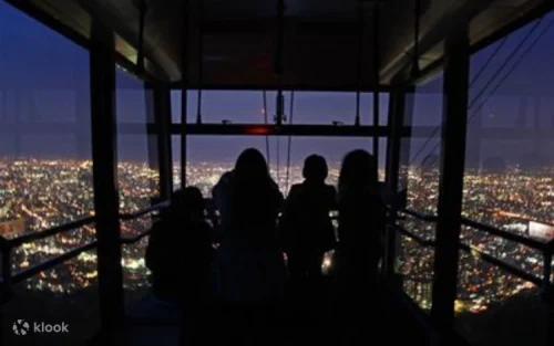 Visitors enjoying the fresh mountain air and stunning landscapes at the Mt. Moiwa summit.
