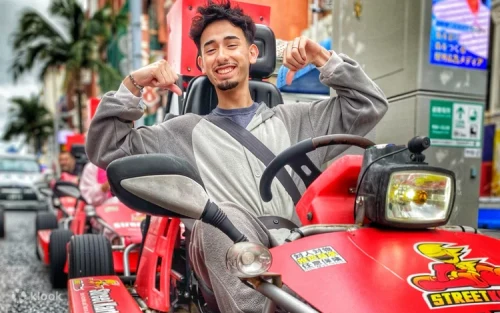 Go-kart driver cruising past Naha Airport with scenic ocean views
