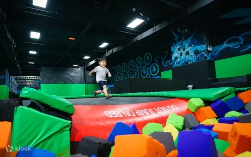 A guest safely landing an aerial flip into a massive soft sponge pool
