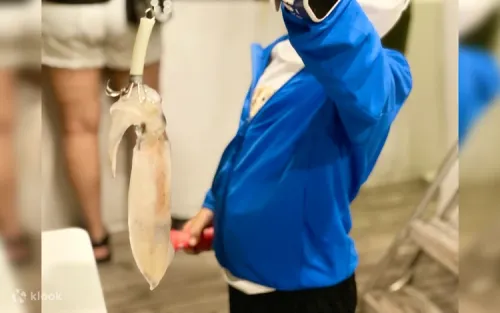 Passengers learning how to catch cuttlefish from the boat deck