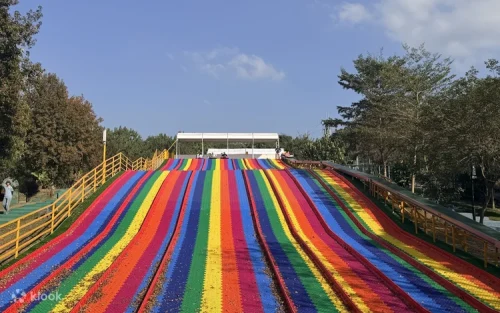 Children sliding down the giant dinosaur slide at Baiguoshan Theme Park