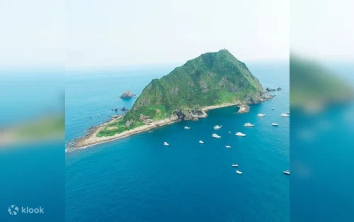 The iconic black and white Keelung Island Lighthouse against a clear sky