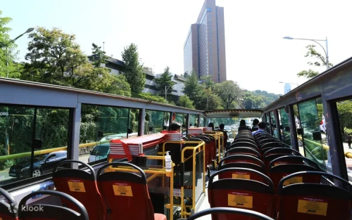Open-top double-decker bus driving through downtown Seoul