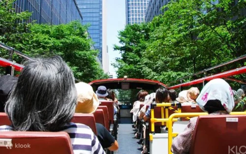 Tourists enjoying the view of Tokyo Skytree from the open-air bus deck