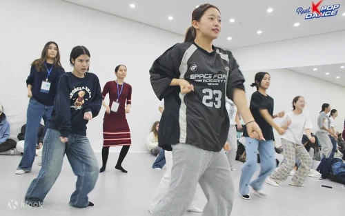 Group of international tourists posing with their K-pop dance certificates