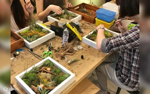 Instructor guiding a student in building a glass terrarium in Singapore