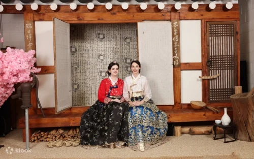 穿著傳統韓服在韓屋佈景前合影的情侶