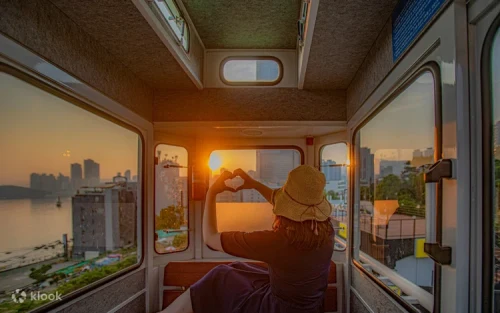 Colorful Haeundae Sky Capsule cars traveling along the coastal railway