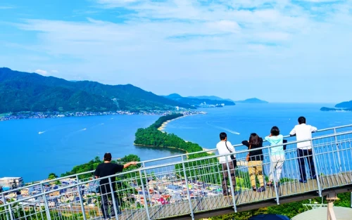 Lush green pine trees lining the white sand beaches of the Amanohashidate sandbar