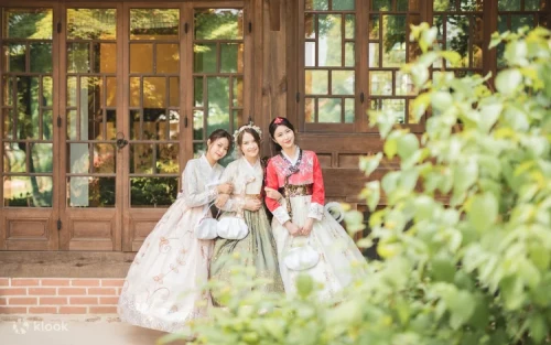 Friends walking through Bukchon Hanok Village wearing colorful traditional attire