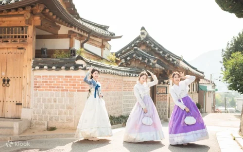 Couple taking photos at a historic Seoul shrine in matching traditional outfits