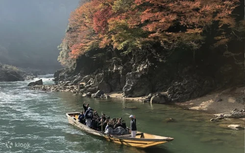 Traditional Japanese wooden boat navigating the rapids of the Hozu River