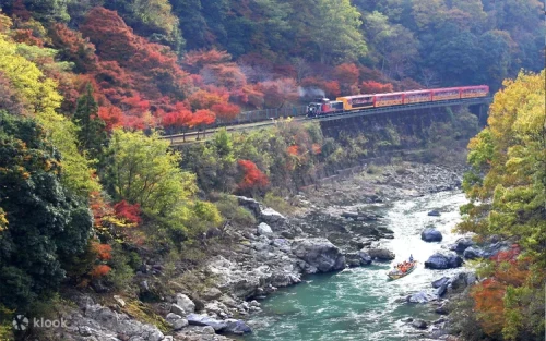 Skilled boatman using a long bamboo pole to steer through Kameoka ravines