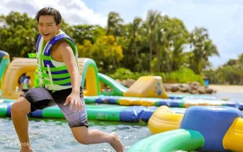 Visitors balancing on the slippery beam at the inflatable water park