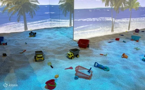 Toddler playing in the sensory wooden pebble pit at Kiztopia