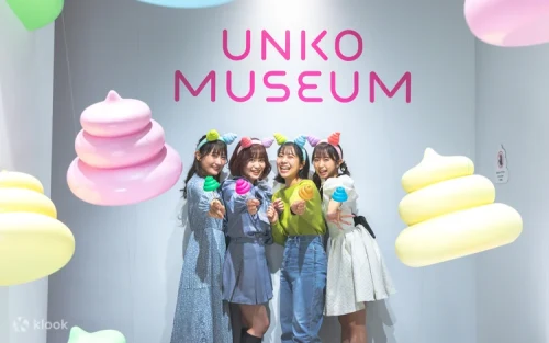 Visitors posing excitedly in front of the glowing pastel Poop Volcano exhibit